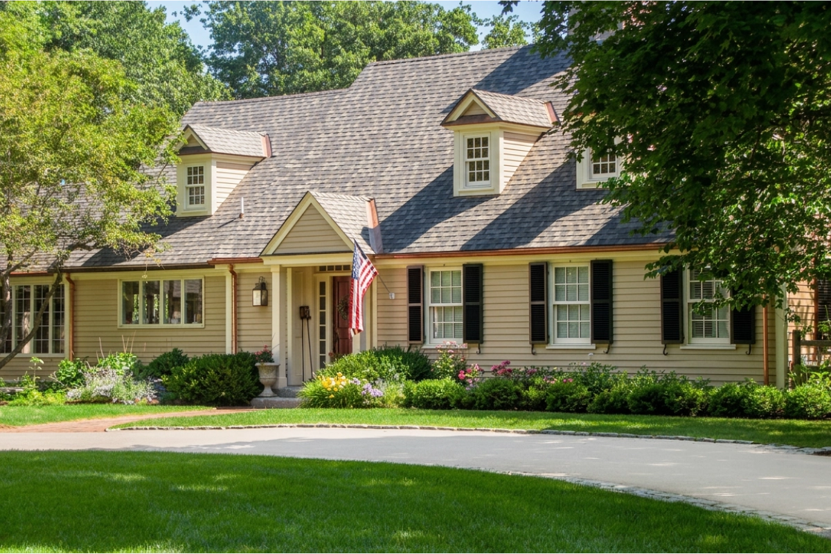 beige painted farm house with driveway and grass