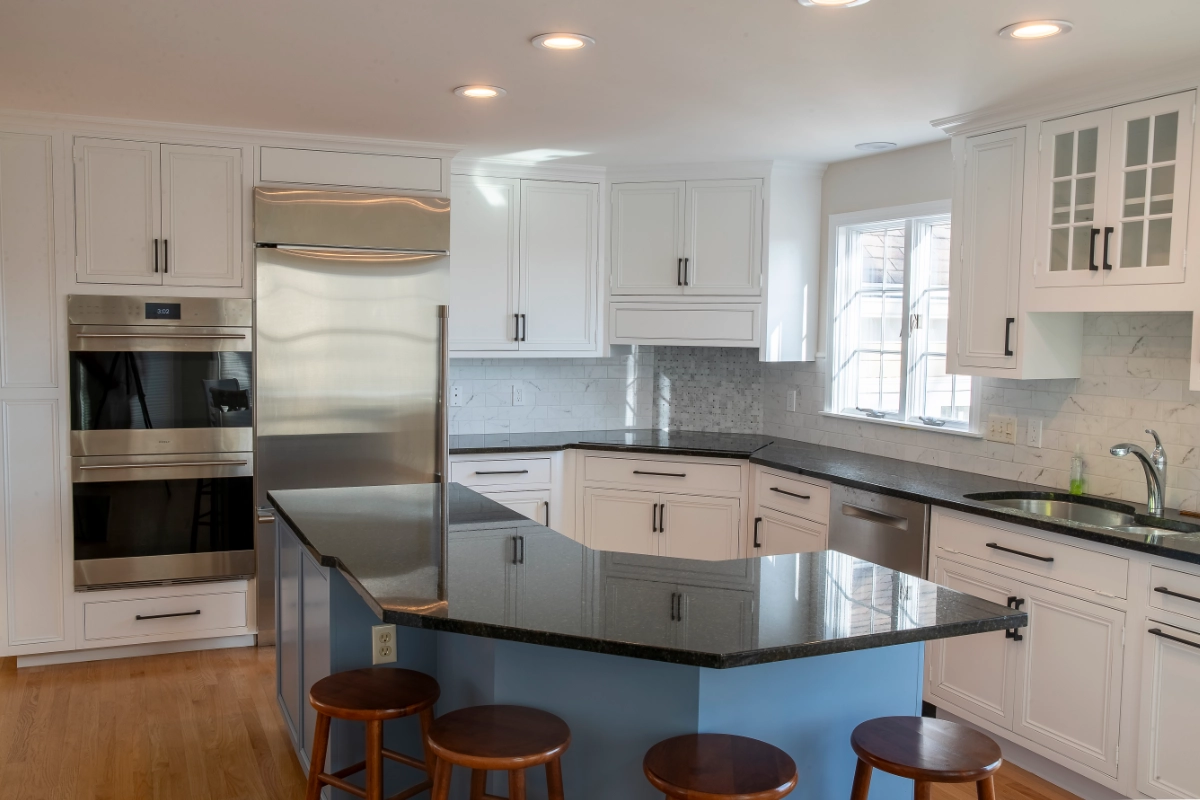home kitchen with white cabinets, blue kitchen island, and stained stools